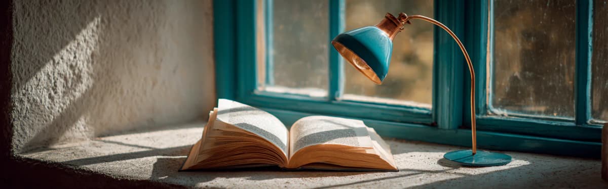 Otvorena knjiga na kamenom stolu pored prozora